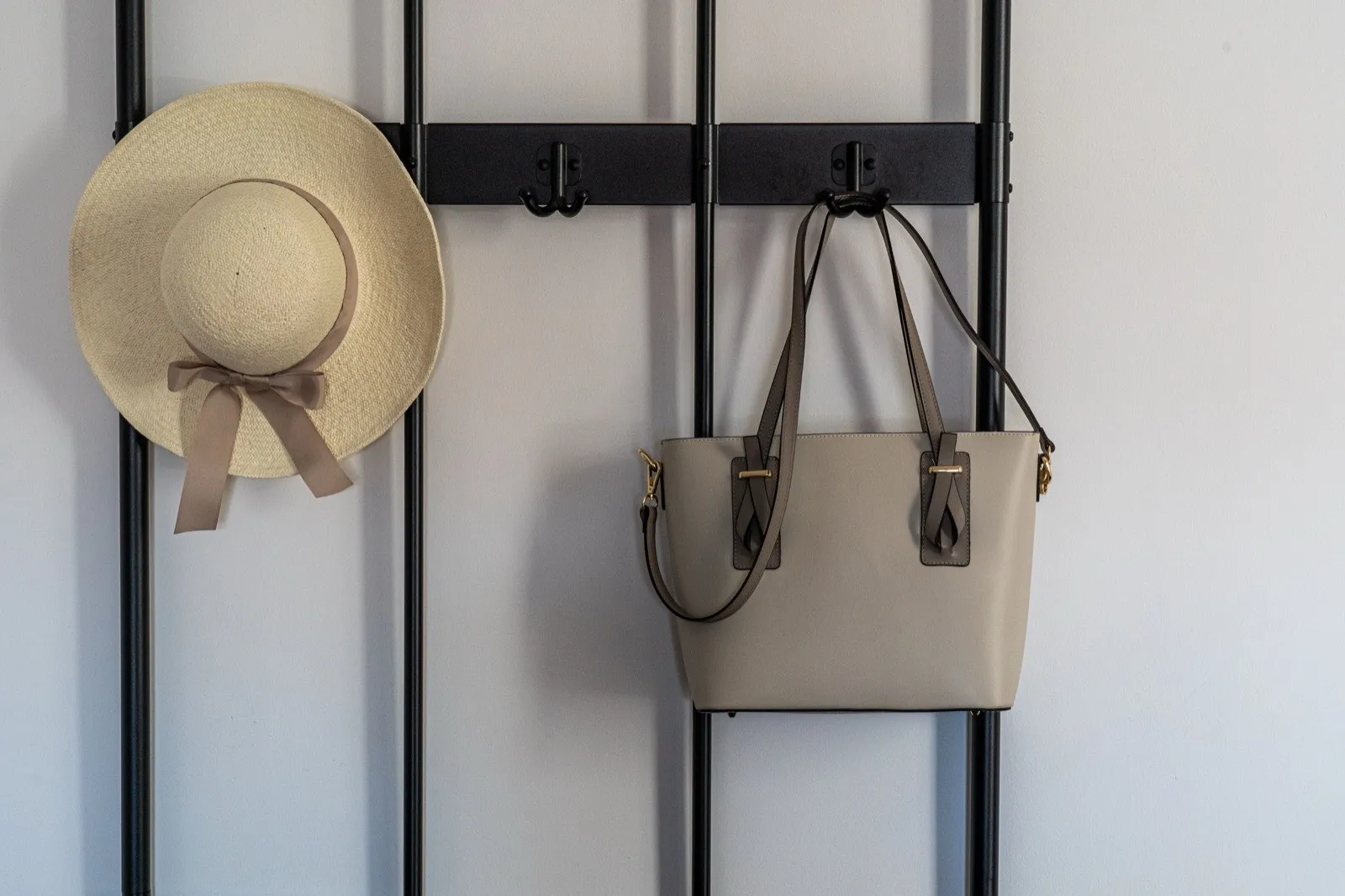 A close-up of a wall-mounted wooden hook board holding an umbrella