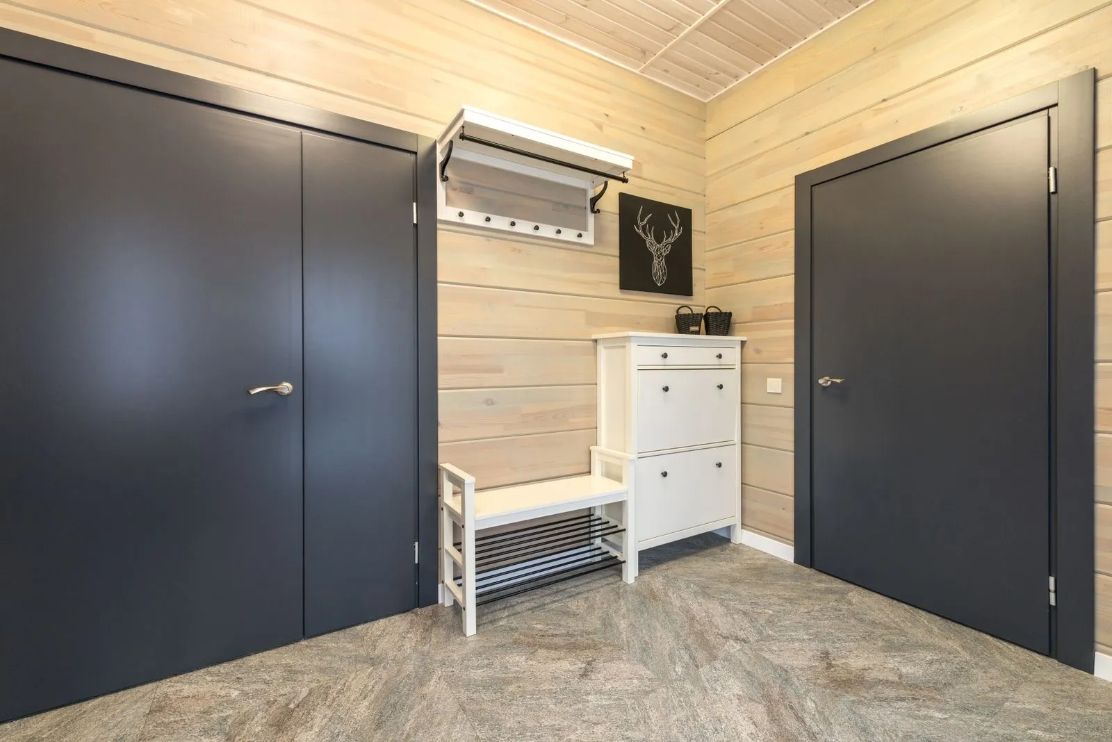 An entryway bench with shoe-rack shelving underneath and coat hooks mounted on the wall above